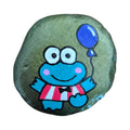 Hand painted green frog in a bow tie holding a purple balloon on a rock