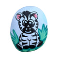 Hand painted baby zebra standing in grass on a natural stone rock