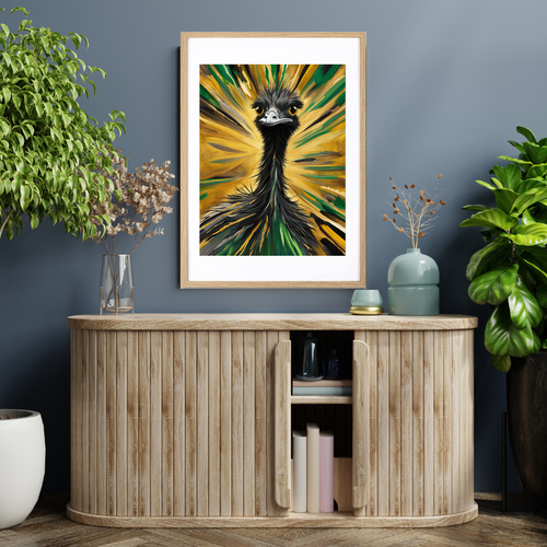 Abstract emu artwork with dramatic green and gold brush strokes displayed in a natural wood frame on a wall above a wooden cabinet