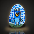 Backyard Buddy, a hand painted blue pup standing in grass rock, on a black and gold background
