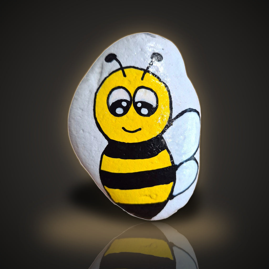 Bea Happy, a hand painted black and yellow bumble bee rock, on a black and gold background