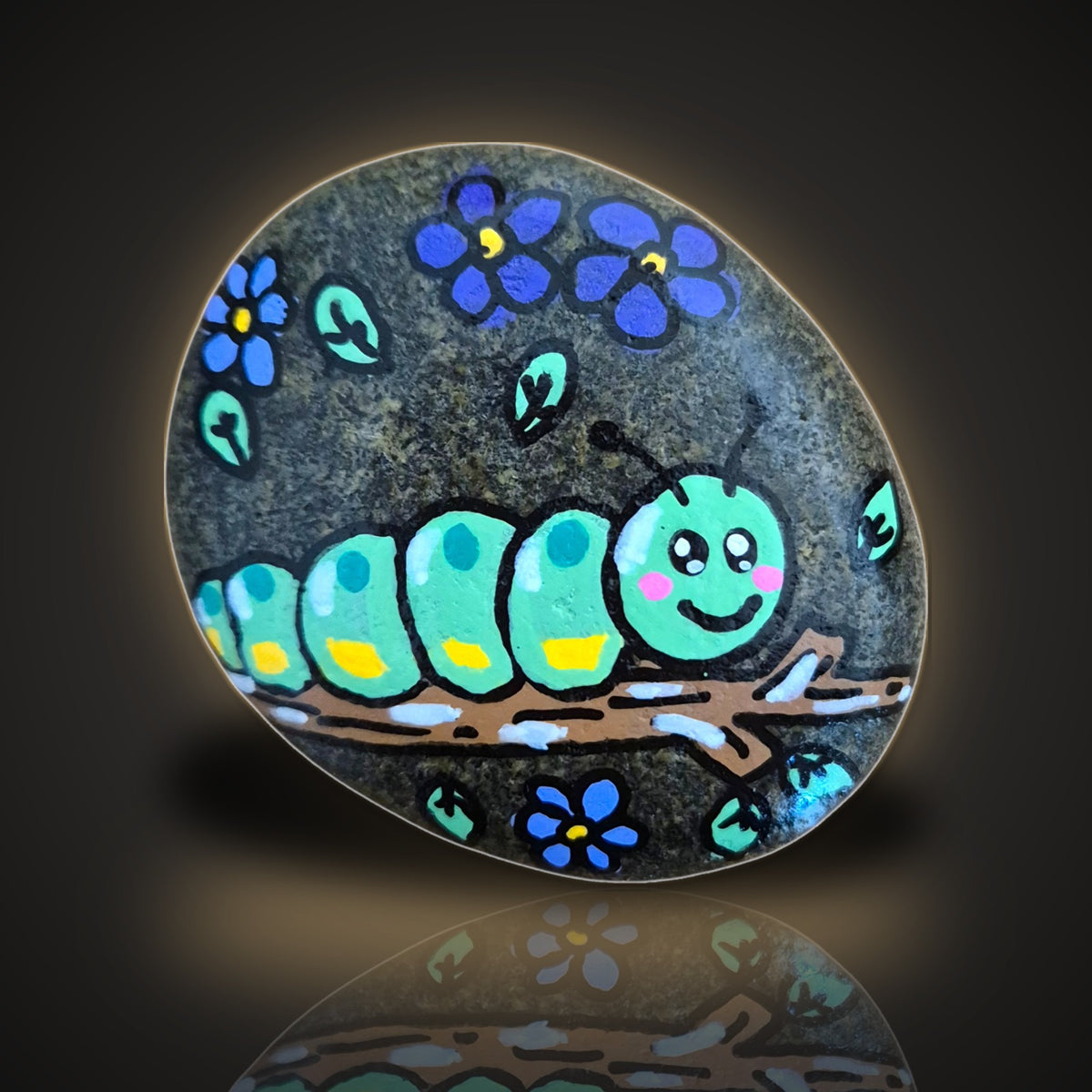 Stick Around Sid, a hand painted caterpillar on a stick rock, on a black and gold background