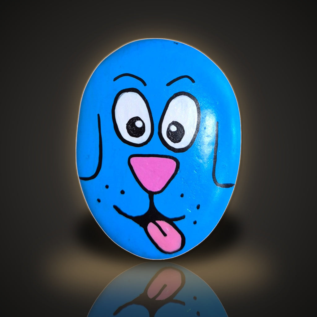 Blep the Blue Pup, a hand painted blue dog rock with its tongue out, on a black and gold background