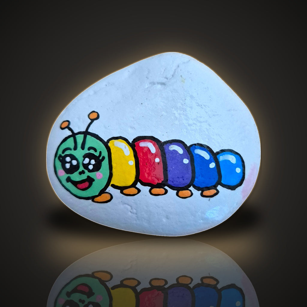 Rainbow Wiggles, a hand painted colourful rainbow caterpillar rock, on a black and gold background
