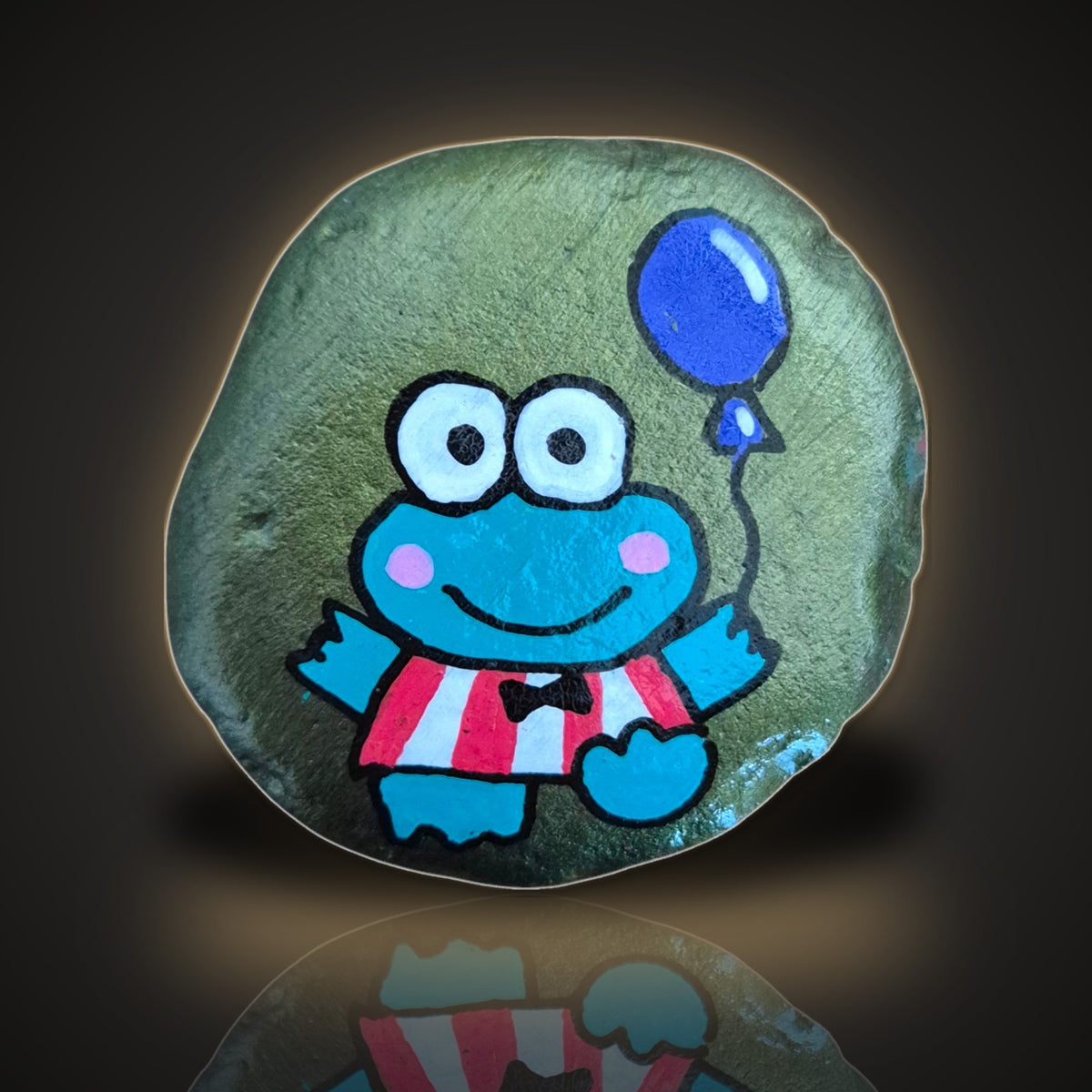 Sir Hops-a-Lot, a hand painted frog rock with a bow tie and balloon, on a black and gold background