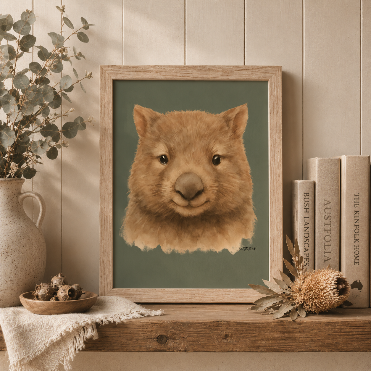 Framed artwork of a wombat's face on a shelf with decorative items.