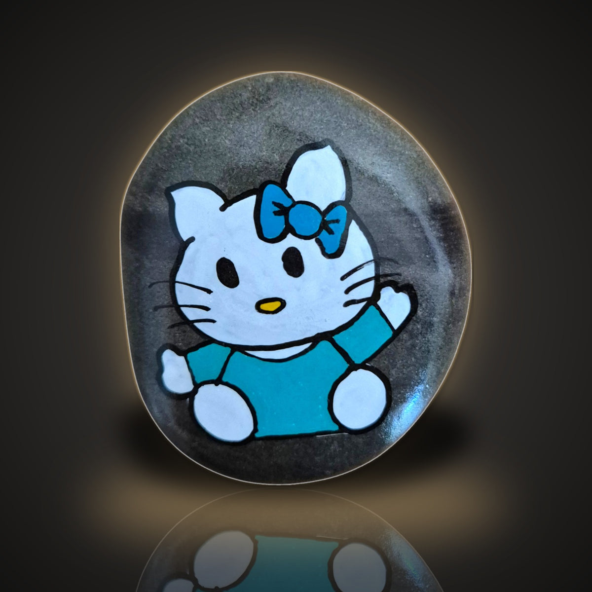 Bow Meow, a hand painted green kitty rock with a bow, on a black and gold background