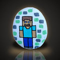 Pixel Pete, a hand painted blocky pixel-style gamer rock, on a black and gold background