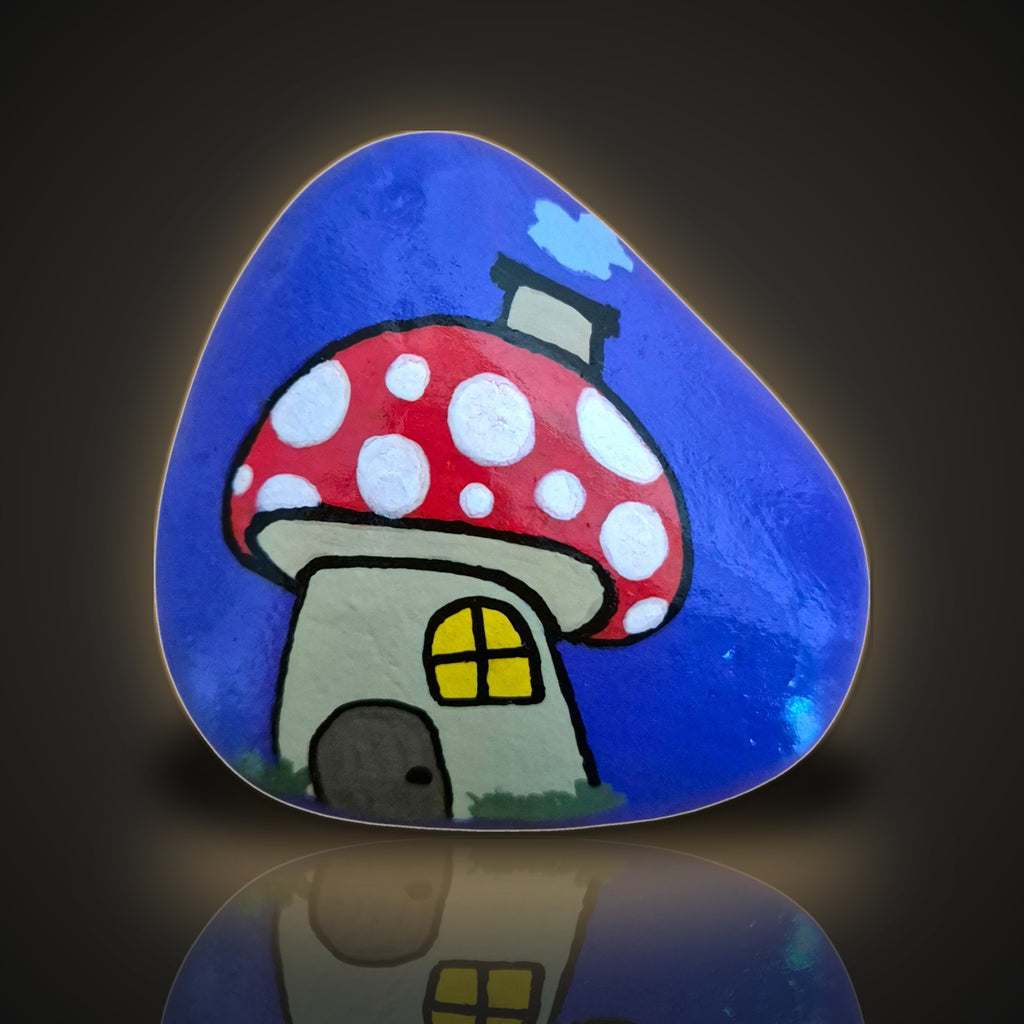 Shroomsville, a hand painted red mushroom house rock on a purple background, on a black and gold backdrop