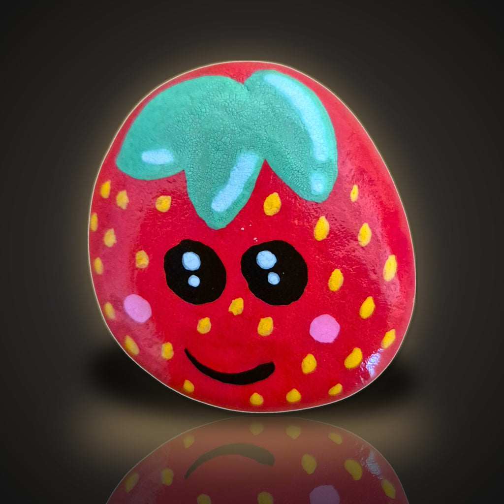 Berry Happy, a hand painted smiling strawberry rock, on a black and gold background