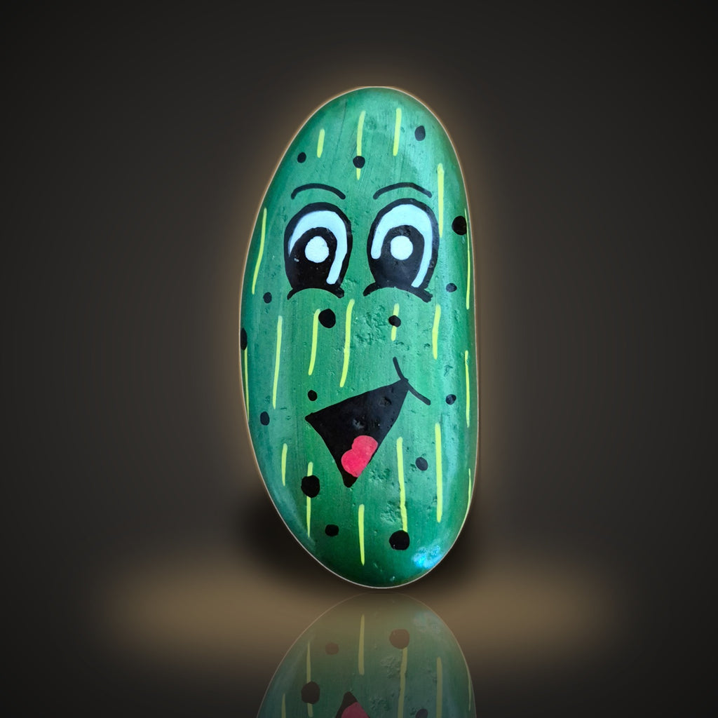 Big Dill, a hand painted smiling pickle rock, on a black and gold background